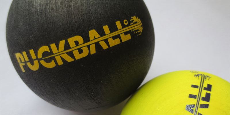 Two PuckBall balls in a photomontage that displays the new product branding.