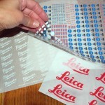 a person peeling off the back of a custom dry transfer sheet used for custom lettering