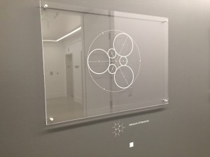 An artwork with a white description label beside it that's a custom dry transfer for walls.