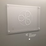 An artwork with a white description label beside it that's a custom dry transfer for walls.