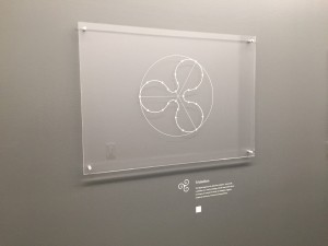 An artwork with a white description label beside it that's a custom dry transfer for walls.