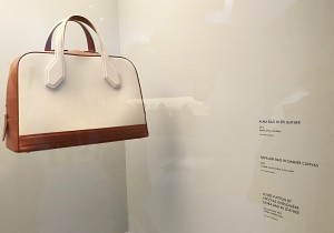 Vintage handbag with custom white exhibit label displaying a description of the artwork.