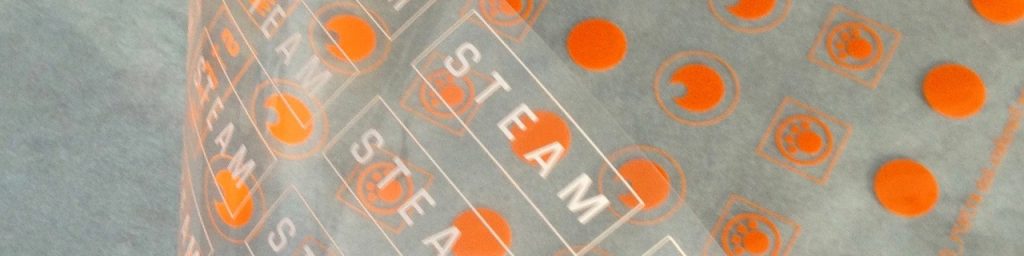 Custom dry transfer labels are affordable when ganged up on an individual dry transfer sheet. A close-up of rub-on labels in orange.