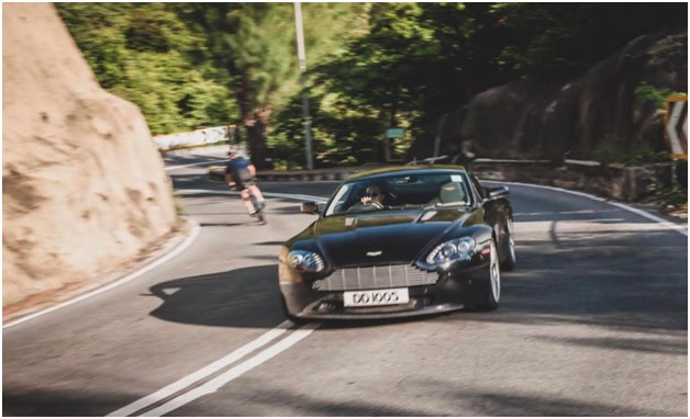 An Aston Martin exotic car driving down the road. Recently restored car using custom rub on transfers.