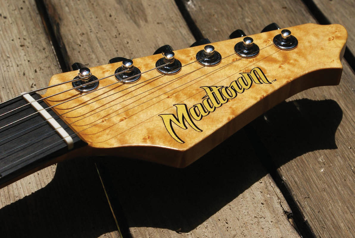 A Madtown Guitar headstock featuring a dry rub transfer