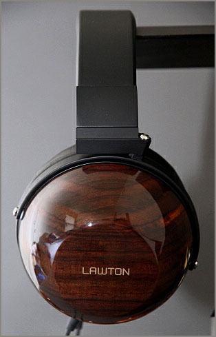 A side view of Lawton Audio headphones. On the wood earpiece is their company logo as a custom rub-on transfer. Additional varnish makes them permanent.